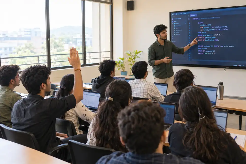 An instructor teaching an SQL session to a classroom of data analytics students